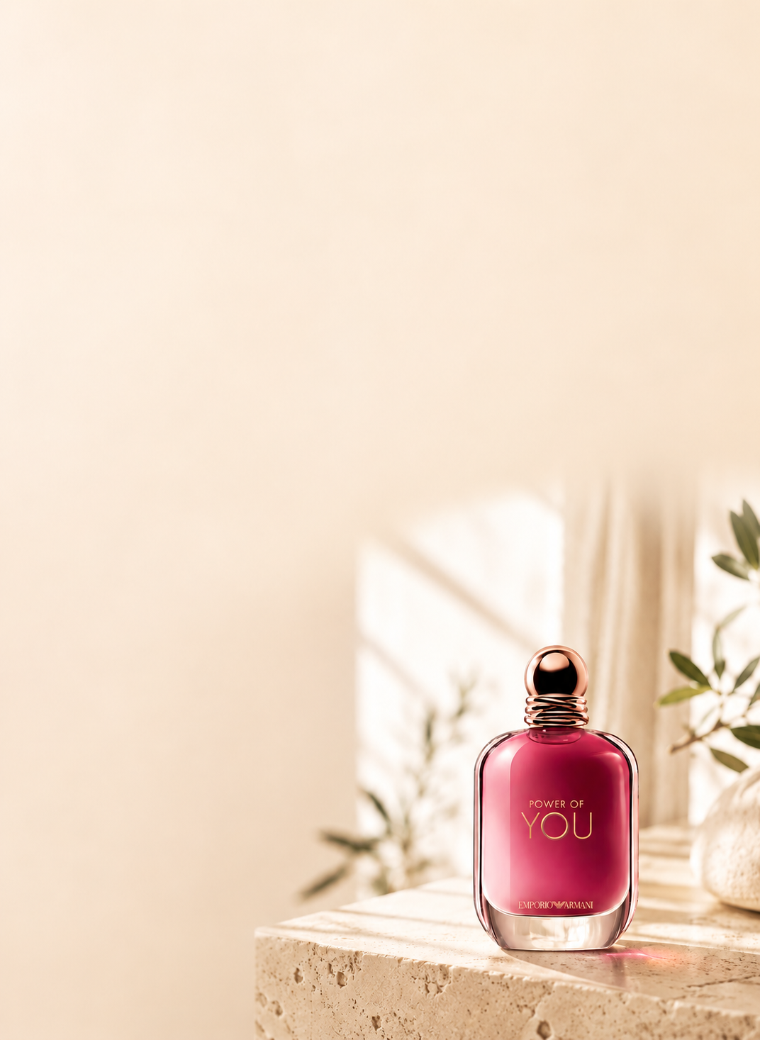 Frasco de perfume sobre travertino com luz de fim de tarde e ramo de oliveira — seleção de perfumes para um encontro